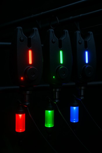 Bite alarms and hangers glowing softly during a night carp session