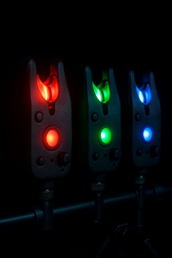 Bite alarms glowing softly on a rod pod against the dark bank