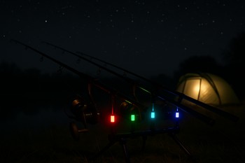 Night view of weekend carp rods glowing under soft camp light